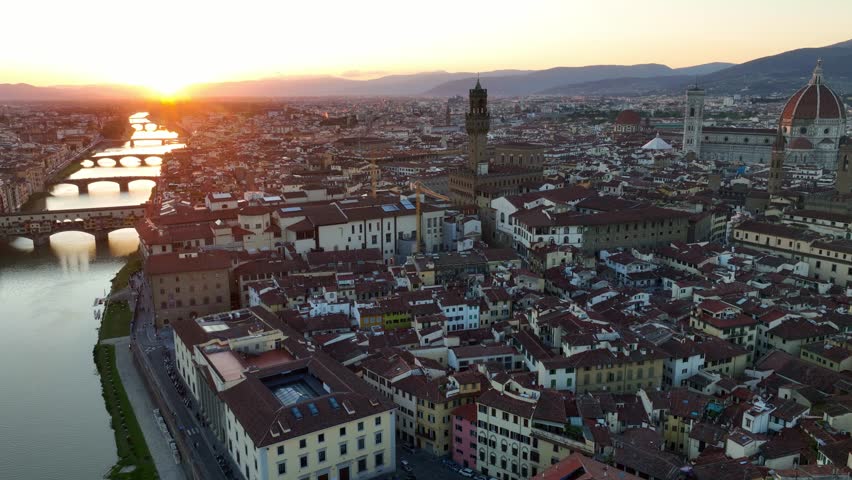 Establishing drone shot of Florence, Florence Cathedral of Santa Maria del Fiore, Ponte Vecchio and Arno River at sunset, Tuscany region of Italy Florence