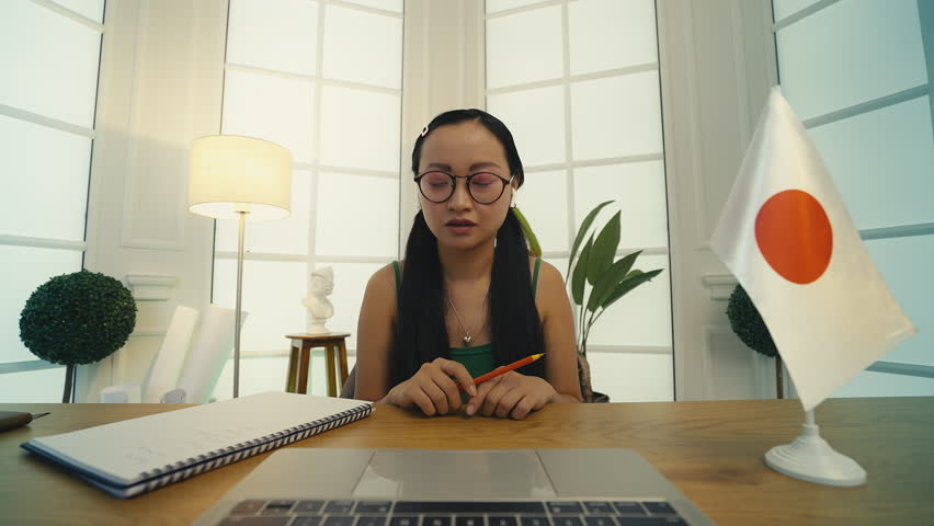 Asian tutor explaining Japanese pronunciation online, foreign language course