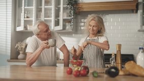 Merry weekend at home, aged married couple cooking salad for dinner in kitchen. Happy elderly spouses spending time together, cooking and drinking coffee, vegetable diet for stay healthy and active - Powered by Shutterstock - Get 15% off with code: PIKWIZARD15