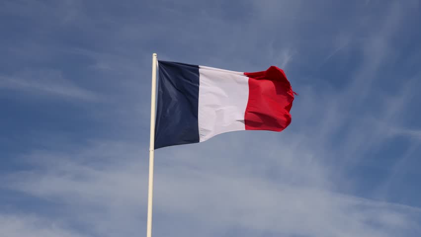 National flag of France flying against a blue sky in Le Touquet, France.
