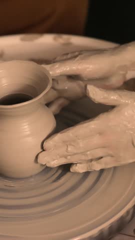 Close-up of hands working with clay on a pottery wheel in an artisan studio. Creative hobby, hands-on ceramic art and mindful handmade craftsmanship.