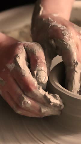 Close-up of hands working with clay on a pottery wheel in an artisan studio. Creative hobby, hands-on ceramic art and mindful handmade craftsmanship.