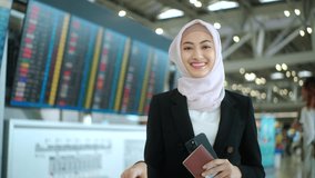 Happy asian muslim business woman wearing hijab holding smartphone and passport standing at airport terminal. Islamic woman people lifestyle travel. Muslim people concept.
 - Powered by Shutterstock - Get 15% off with code: PIKWIZARD15