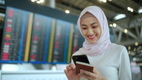 Young asian muslim woman wearing hijab using smartphone checking flight at airport terminal. Islamic woman people lifestyle travel. Muslim people concept.
 - Powered by Shutterstock - Get 15% off with code: PIKWIZARD15