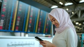 Young asian muslim woman wearing hijab using smartphone checking flight at airport terminal. Islamic woman people lifestyle travel. Muslim people concept.
 - Powered by Shutterstock - Get 15% off with code: PIKWIZARD15