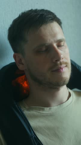 Mature caucasian experiencing soothing warmth and muscle tension relief through electric heating pad, resting with closed eyes and embracing personal wellness moment