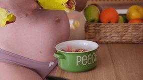 Close up of pregnant woman pouring cereal into her plate. Unhealthy pregnancy food concept. Harmful and fast food - Powered by Shutterstock - Get 15% off with code: PIKWIZARD15