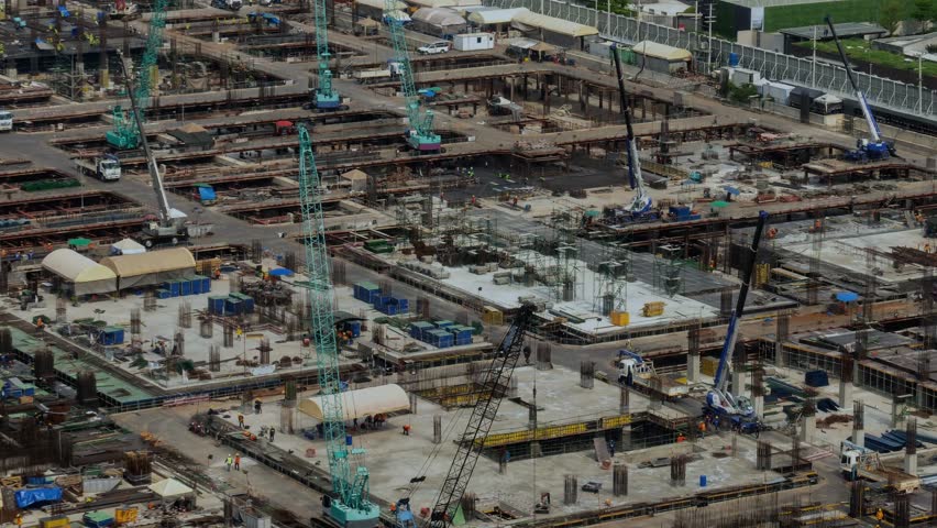 Construction technology concept with alteration graphic over construction site showing concept of automation and remote wireless machine control by using futuristic HUD in a computer software .