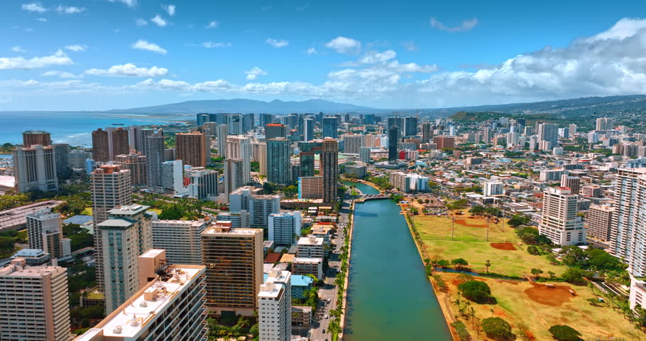 View on the stunning Honolulu from above the Ala Wai Canal. Sunny panorama of the city from aerial perspective.