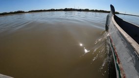 View of the bow and board wooden canoe sailing over river water of western Madagascar in sunny day - Powered by Shutterstock - Get 15% off with code: PIKWIZARD15