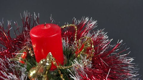 person lighting the red Christmas candle ornament
