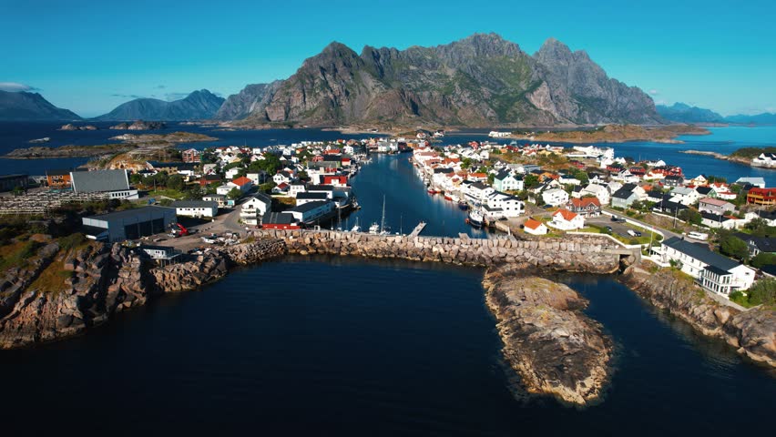 Henningsvær aerial showing the town, harbor, and mountain peaks of the Lofoten islands in Norway.