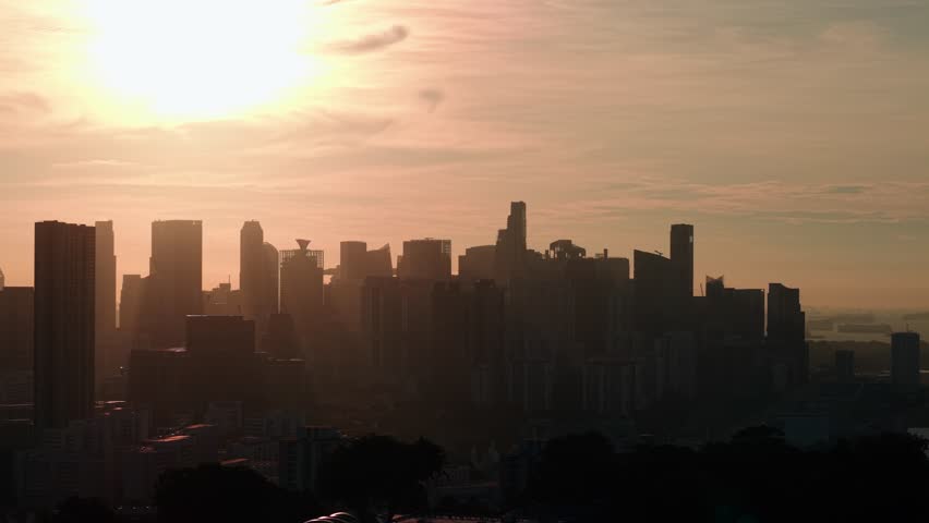 Aerial Sunset Sky At Downtown City Singapore. Cityscapes Downtown City Singapore. Urban Skyline at Sunrise. Captured with a drone using a zoom lens, the camera smoothly pans from left to right.