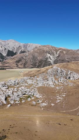 Vertical drone overview of Castle Hill rock formations in New Zealand on sunny afternoon