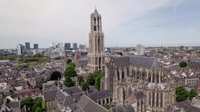 Slow ascending aerial movement showing gothic architecture of cathedral and De Dom church tower in historic city center of Utrecht with Dutch high rise buildings in background - Powered by Shutterstock - Get 15% off with code: PIKWIZARD15