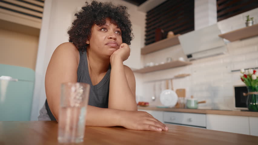 Hormonal mood swings in pregnancy, portrait of sad black woman drinking water. Unhappy depressed lady feeling sadness and boredom, overweight female person want to lose weight, diet for stay slender
