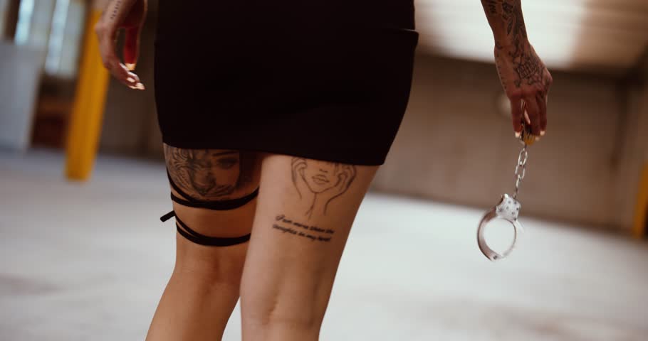 Edgy female model walking with handcuffs in hand – close-up shot