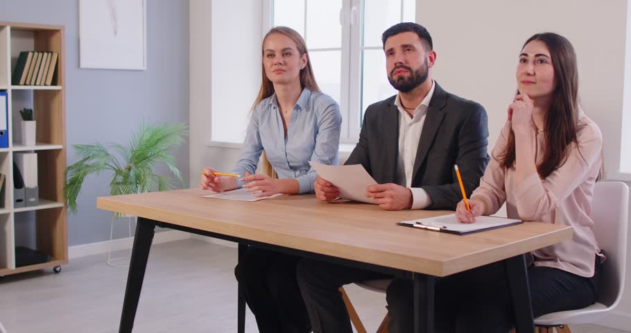 Confident male job applicant shaking hands with group of recruiters before interview in office. Panel of smiling HR managers greeting candidate with handshake, conducting hiring process in workplace.