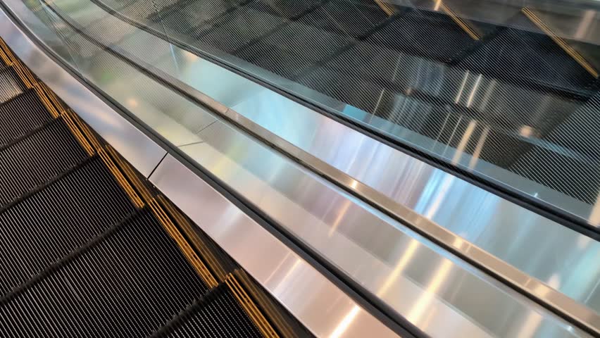 Polished stainless steel handrail gliding smoothly along escalator surface, reflecting surrounding architectural elements within contemporary shopping mall interior