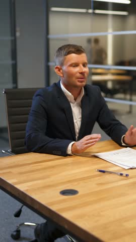 The man and woman speaks with lawyer in bank boardroom. Modern glass business center. Sign mortgage documents. Vertical shot.