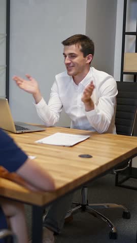 Family with realtor in boardroom discussing about house purchasing contract. Redhair female and her husband very interested in signing documetns. Vertical shot.