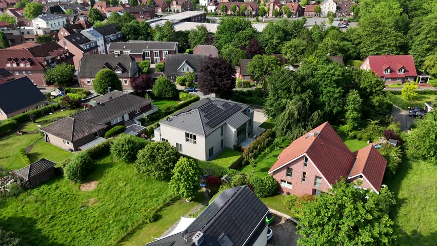 Noble residential apartment house with solar panels on roof during sunny day. Aerial orbit shot. Spring day in America. White facade with terrace and balcony. Production of green energy.