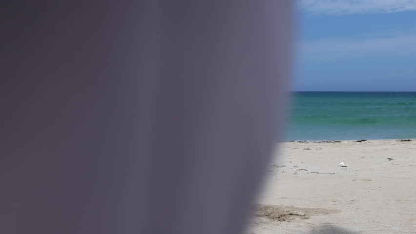 A father and son draw with their feet in the sand.
