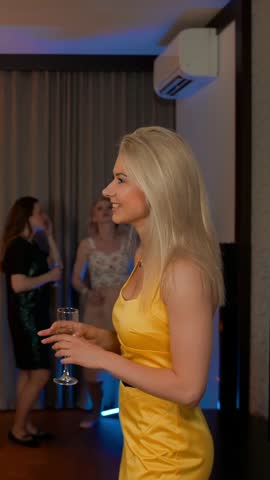 Sexy young couple meet flirting at glamorous party drinking champagne cocktail in love having fun together feeling attraction. Vertical shot.