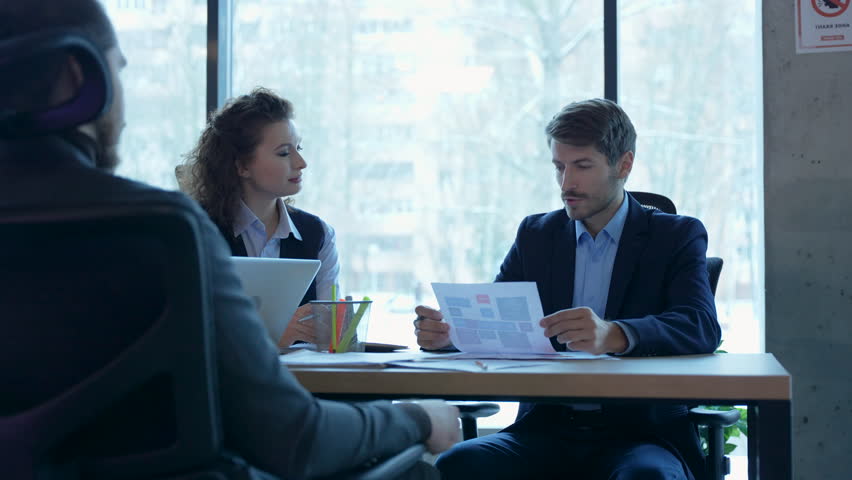 Busy business people having corporate business discussion at group meeting, team working together discussing project at office table.