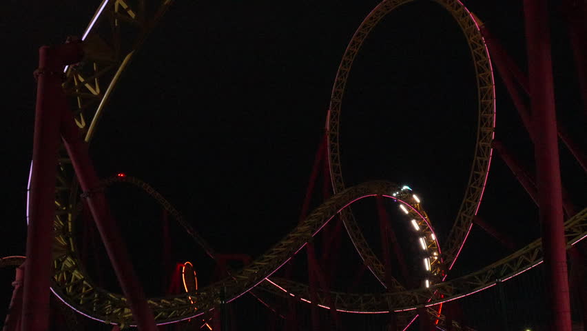 Rollercoaster Night Ride Loop Amusement Park: Thrilling nighttime rollercoaster loop ride at an amusement park, showcasing exhilarating speed and dynamic lighting.
