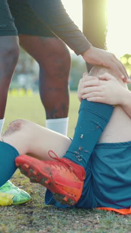 Hands, soccer and kid with knee injury on field for sports competition, tendinitis and pattelar dislocation. People, coach and helping player with kneecap fracture, torn ligament and accident support