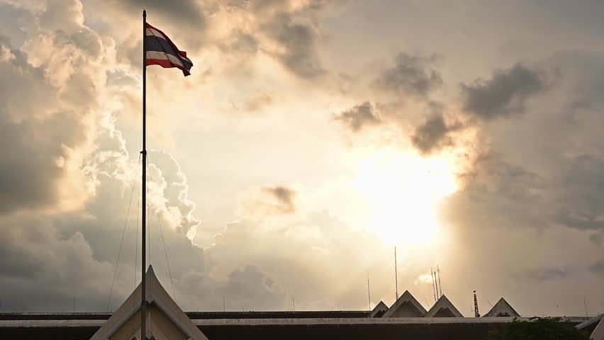 A Thailand national flag blowing by wind against sunset. Flag of Thailand shows five horizontal stripes in the colours.