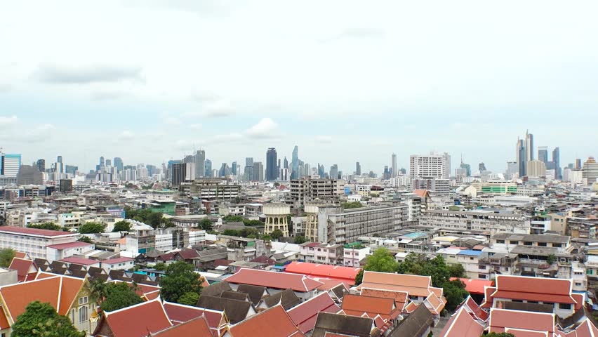 BANGKOK, THAILAND - AUGUST 2024 : Aerial high angle view of cityscape of Bangkok city. View of buildings and streets in downtown area. 4K time lapse shot in daytime.