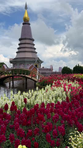 Serene landscape featuring a majestic pagoda nestled amidst vibrant flower gardens and a tranquil pond, creating a picturesque scene of natural beauty and architectural harmony.