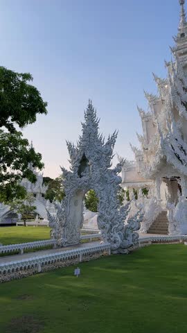 Stunning architecture of Wat Rong Khun, the White Temple in Chiang Rai, Thailand. Intricate details and serene setting create a captivating image.