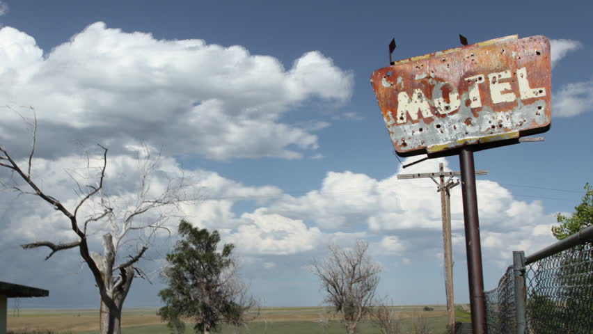 Timelapse of clouds behind an old, creepy motel sign, complete with