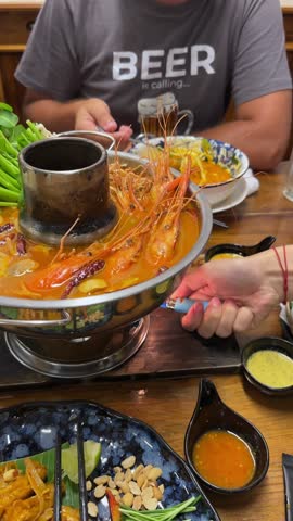 Delicious Tom Yum Goong, a spicy Thai soup brimming with succulent prawns, mushrooms, and vibrant vegetables. Aromatic broth and fresh herbs create a flavorful culinary experience.