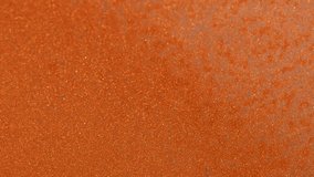 Close-up of bright orange glitter surface with fine grains and soft diagonal shadow, abstract shimmering texture - Powered by Shutterstock - Get 15% off with code: PIKWIZARD15