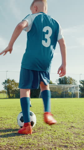Kick, kids or boy soccer player with goal for winning at game or match in youth tournament. Sports, exercise or back of football athlete shooting ball in net at target practice on field at stadium