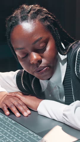 Black woman, business and sleeping at night with laptop, deadline burnout and exhausted in office. Resting employee, workaholic and overtime at tech with fatigue, low energy or overwhelmed with tasks