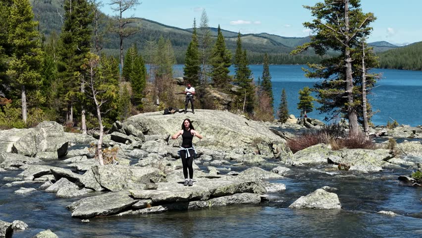 A young woman dances on rocks in the mountains. A couple travels to Altai and visits the Multinsky lakes.