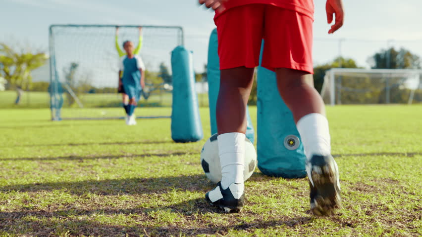 Boy, dribble and ball for soccer practice with inflatable, team training and fitness exercise. Children, equipment and drill with net for sports workout, skills technique and agility for match game