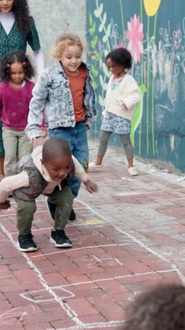 Children, teacher and jump for hopscotch outdoor, recess or playground with energy at kindergarten academy. Playful, fun and hopping or student growth, development or games in school courtyard