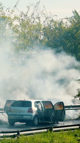 Emergency Response Team Attending a Roadside Car Fire Incident on a Sunny Day