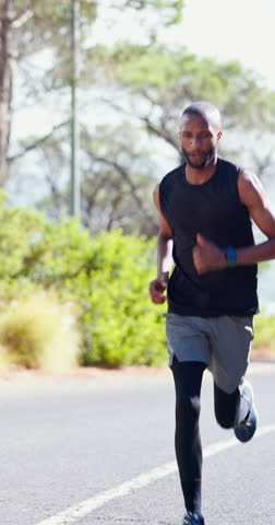 Fitness, running and sports with black man on street in nature for cardio or marathon training. Exercise, performance and wellness with athlete or runner on asphalt road for challenge or commitment