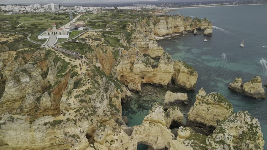 Drone flies north from the sea over caves and grottos at Ponta da Piedade in Lagos, Portugal