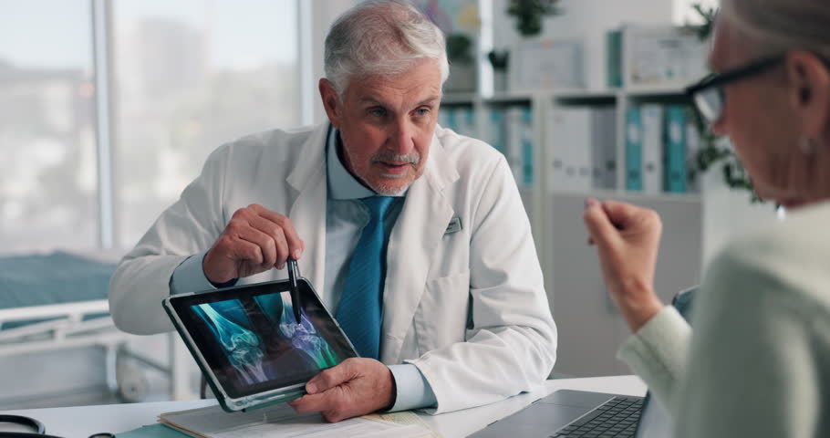 Doctor, senior woman and tablet for x ray with review for broken bones, osteoporosis or knee pain. People, touchscreen and medical consulting for arthritis, feedback and report for wellness at clinic