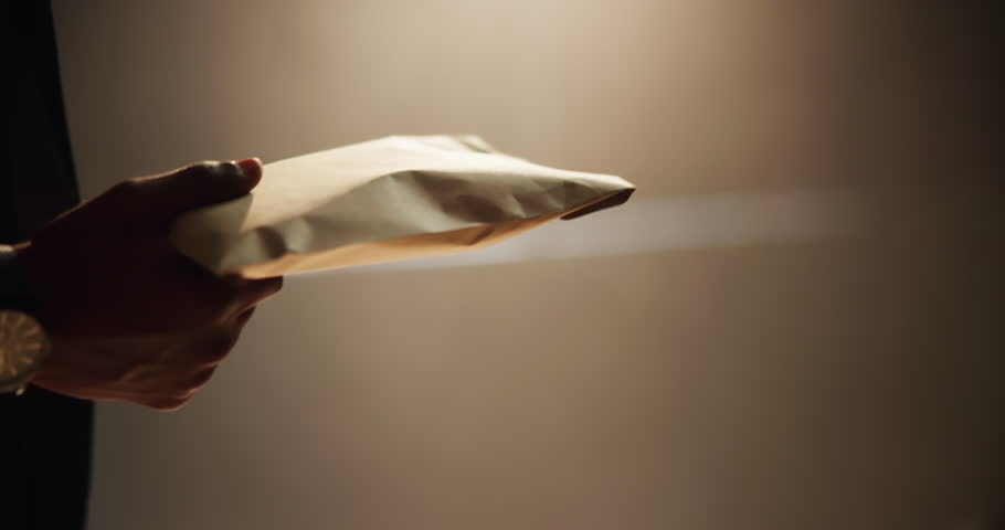 People, bribery or hands with payment for corruption, money laundering or settlement in crime syndicate. Workplace, night or closeup of fraud exchange in scam, brown paper bag or illegal business