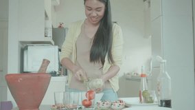 A young woman prepares fresh vegetables in a well-lit modern kitchen, showcasing culinary skills and healthy eating. - Powered by Shutterstock - Get 15% off with code: PIKWIZARD15