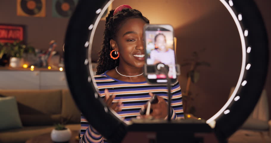 Makeup, influencer and ring light with black woman and phone for cosmetics promotion, brand and vlog. Beauty sponsorship, follower engagement and content creator with person in home for recording